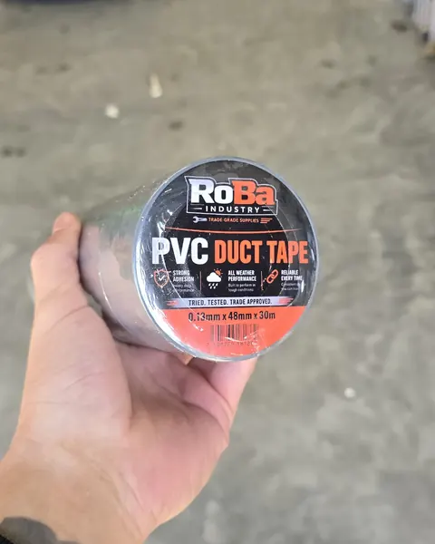 A roll of RoBa PVC duct tape, 0.13mm × 48mm × 30m, held up in a warehouse